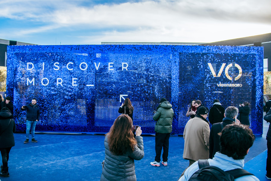 Visitors taking pictures of the blue sequin wall at VicenzaOro.