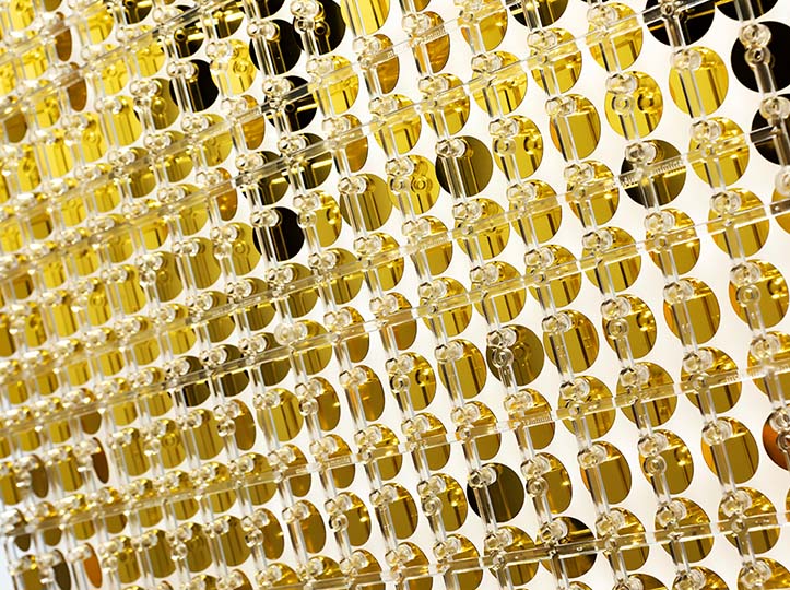 The backing board of a sequin wall in gold.