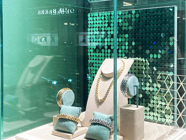 A gold sequin wall in a shop window display for a jewellery brand