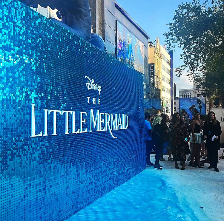 A movie premiere event design with a blue sequin wall.