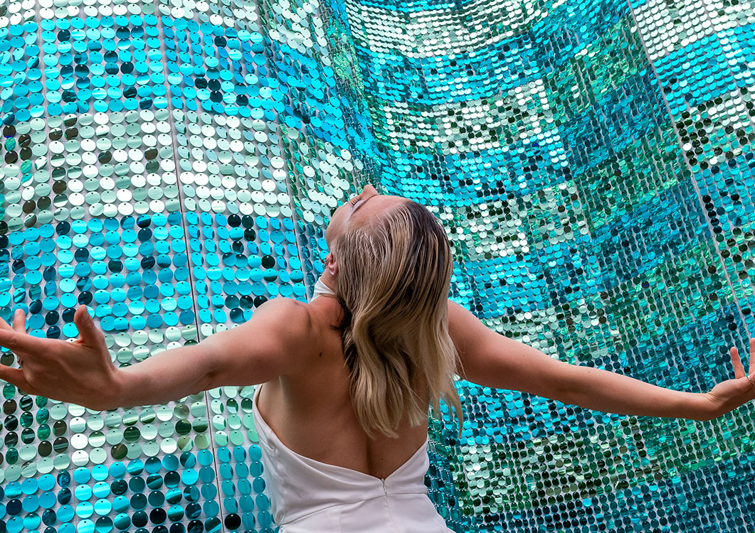 A woman standing in front of a turquoise Shimmerwall.
