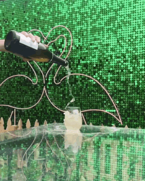Sequin backdrop in green with champagne spraying.