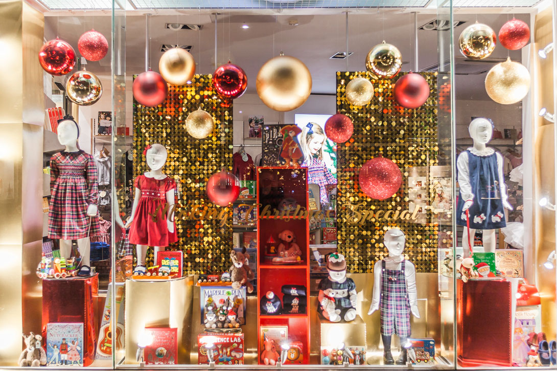 Sparkling gold shimmer sequin wall used as a Children’s store window backdrop for Christmas visual merchandising display